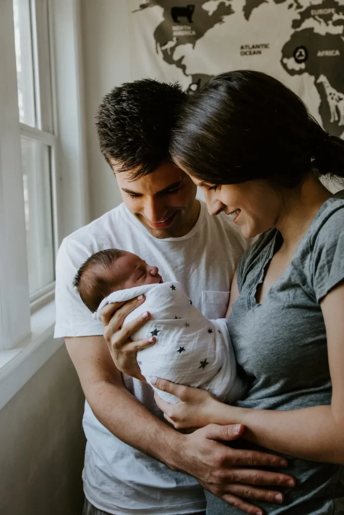 A couple holding a newborn baby after postpartum care in Cincinnati